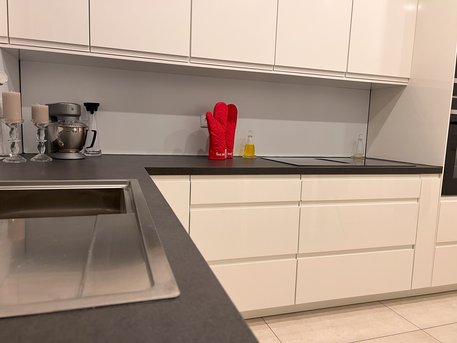 Referenzküche in Weiß Lack Hochglanz mit Arbeitsplatte in Schwarz geflammt von Ihrem Küchenstudio in Aachen